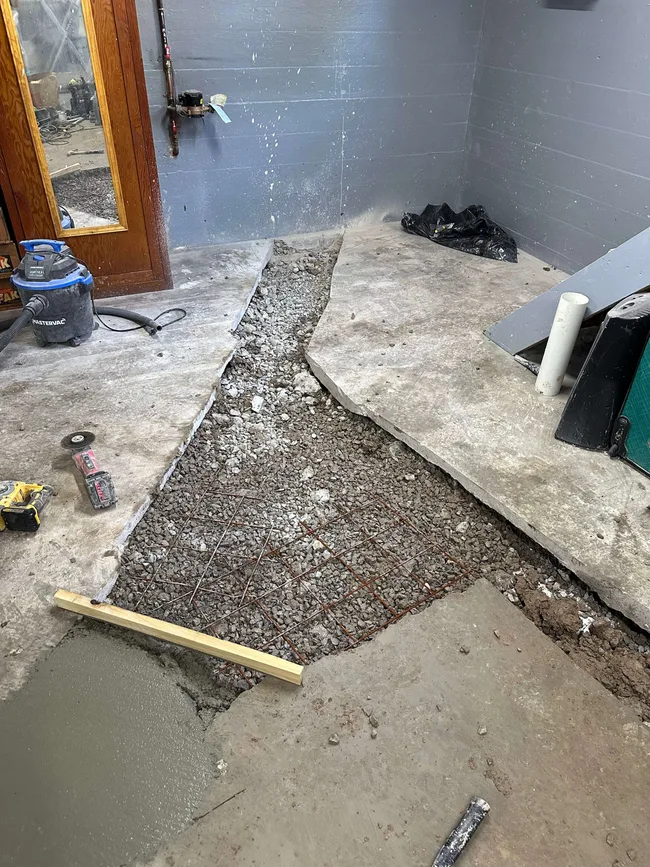 Concrete floor opened for residential sewer line repair in Niagara region — Flow-State Plumbing replacing damaged drain pipes and preparing to pour new concrete