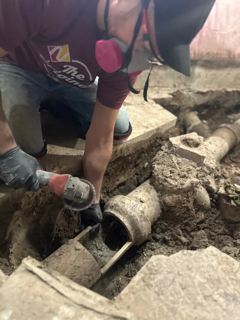 A plumber in St. Catharines repairing a clients 6 inch clay sewer line in their homes basement