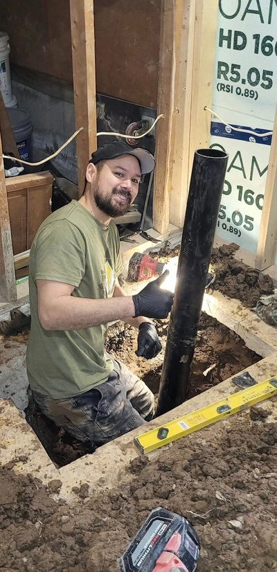 A plumber in Welland repairing a sewer line in a customers basement.