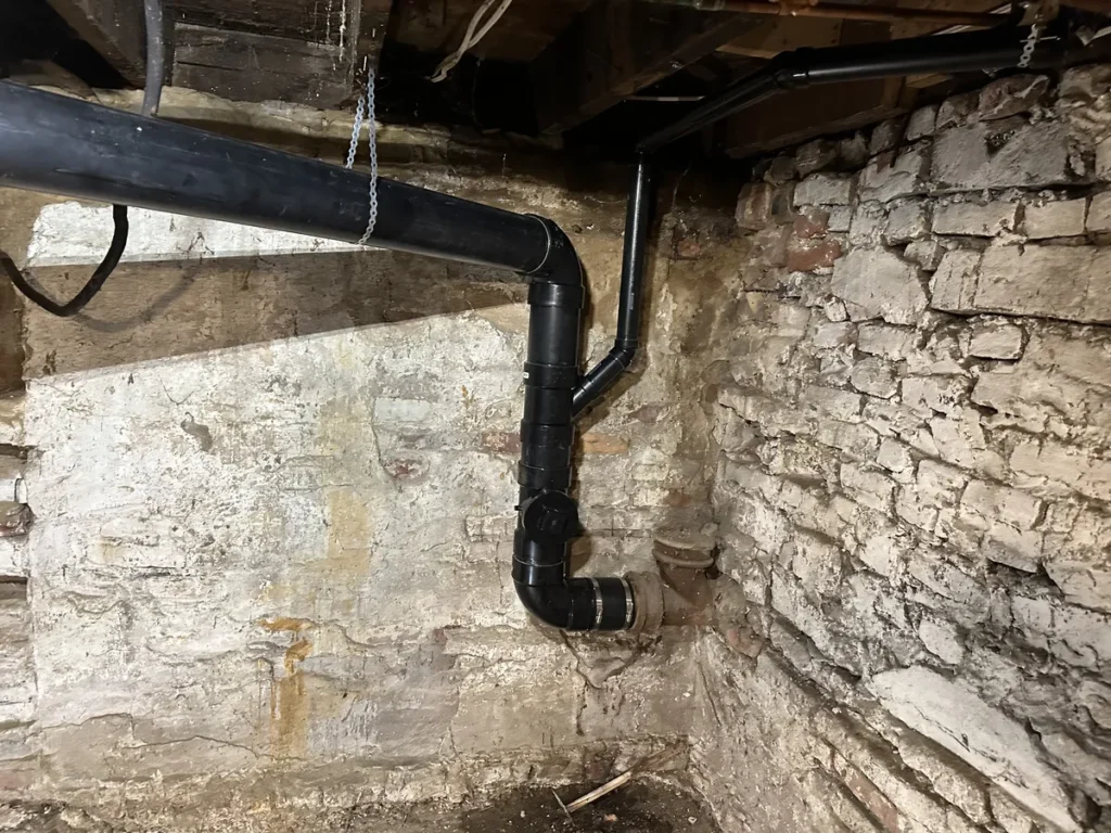 Section of repaired sewer line with abs pipe in a downtown St. Catharines clients home.